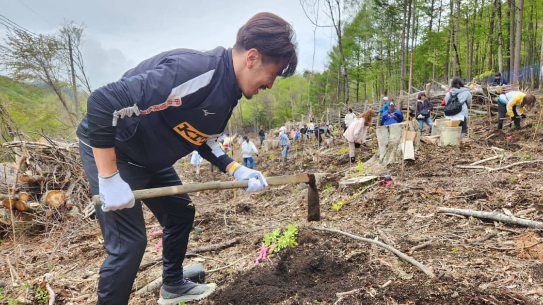 植樹イベントで選手が土を耕している様子